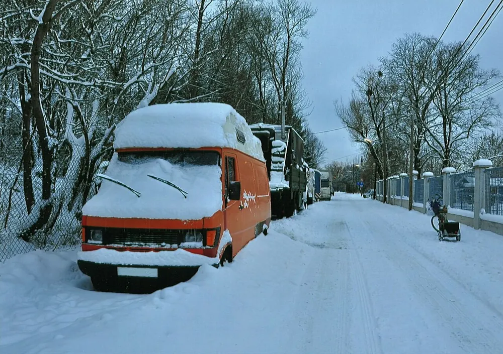 Gammel campingbus parkeret i sne om vinteren